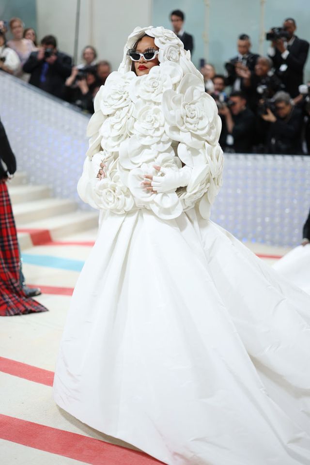  Rihanna được báo chí ca ngợi với hình tượng cô dâu lộng lẫy bên chiếc váy Valentino màu trắng giấu trong áo khoác có mũ trùm kín đầu. Hình ảnh này của Rihanna khiến người ta nhớ lại tinh thần của những cô dâu Chanel - các vedette đã khép lại fashion show cao cấp của Karl Lagerfeld  