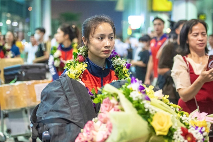 Cầu thủ Hoàng Thị Loan cùng đồng đội tại Sân bay Quốc tế Nội Bài. (Ảnh: Tuấn Đức/TTXVN)