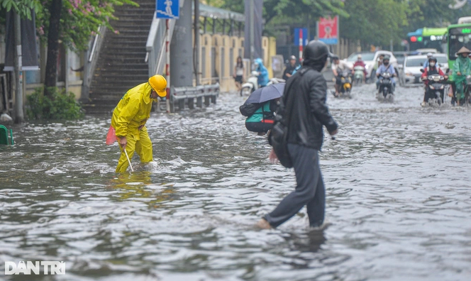  Công nhân Công ty thoát nước Hà Nội ứng trực, khơi thông dòng chảy trên đường Nguyễn Trãi, đoạn gần cổng trường Đại học Khoa học Xã hội và Nhân văn.  