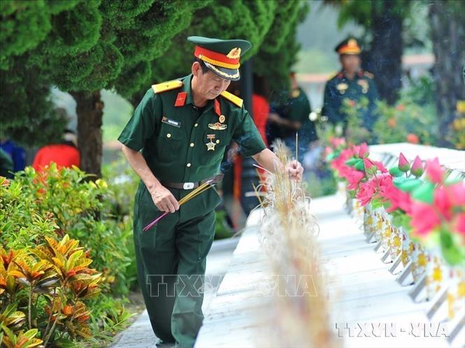 Các cựu chiến binh thắp hương tưởng nhớ các liệt sĩ tại Nghĩa trang liệt sĩ quốc gia Vị Xuyên (Hà GIang). Ảnh: Nam Thái/TTXVN