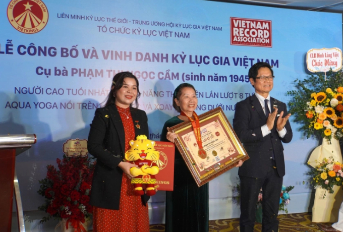  Tổ chức Kỷ lục Việt Nam (VietKings) trao bằng chứng nhận cho cụ bà Phạm Thị Ngọc Cầm (giữa)  