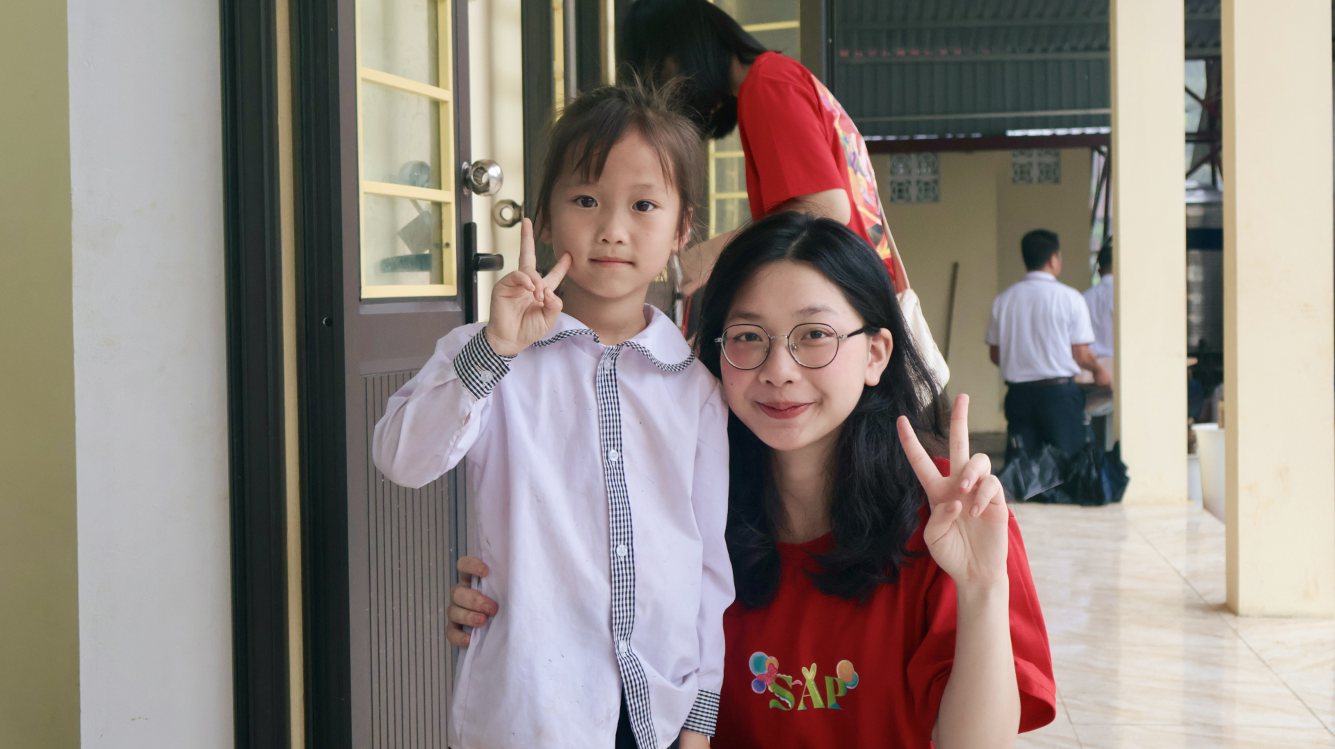 Thành viên BTC chụp ảnh cùng 1 học sinh tại điểm trường Lũng Hoài.