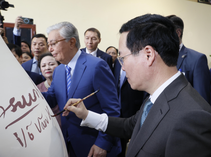Chủ tịch nước Võ Văn Thưởng và Tổng thống Kazakhstan Kassym-Jomart ký lưu niệm lên bình Gốm Chu Đậu. (Ảnh: Thống Nhất/TTXVN)