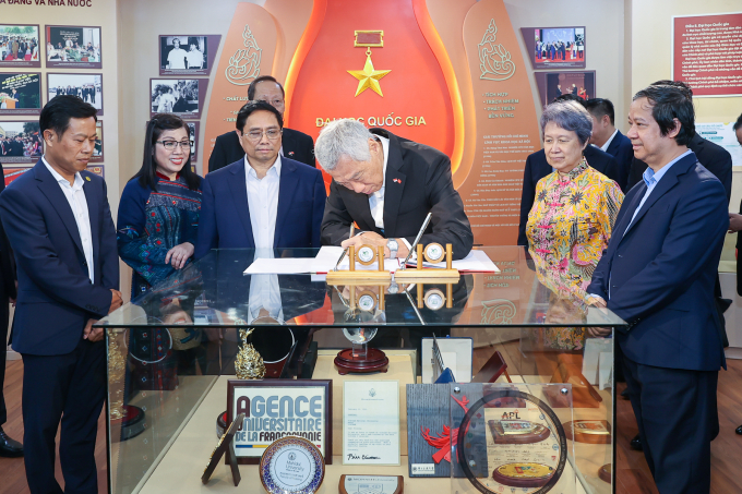 Hai Thủ tướng ghi lưu bút tại phòng truyền thống ĐHQGHN - Ảnh: VGP/Nhật Bắc