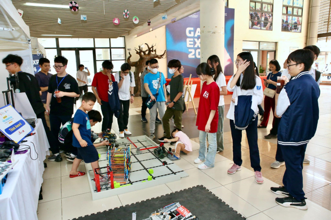 Các em nhỏ và học sinh được giới thiệu và thử lái những robot VEX IQ