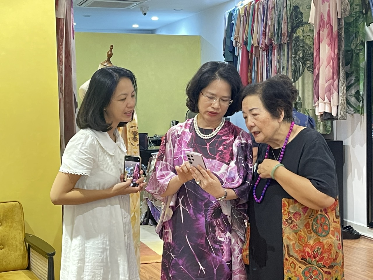 Chị Văn Hằng, chủ thương hiệu DeSil giới thiệu với bà Nguyễn Thị Hồi-Phó Chủ tịch phụ trách đối ngoại Hội Nữ trí thức Việt Nam về các mẫu áo dài mà công ty chị độc quyền.