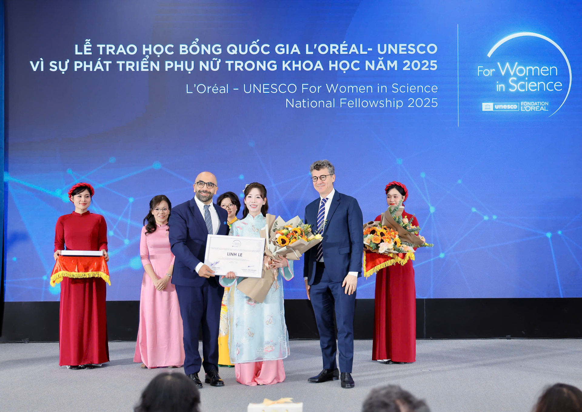  Ông Wagih Ahmed, Tổng Giám đốc L’Oréal Vietnam và ông Jonathan Wallace Baker, Trưởng đại diện UNESCO tại Việt Nam trao chứng nhận học bổng cho TS Linh Lê.