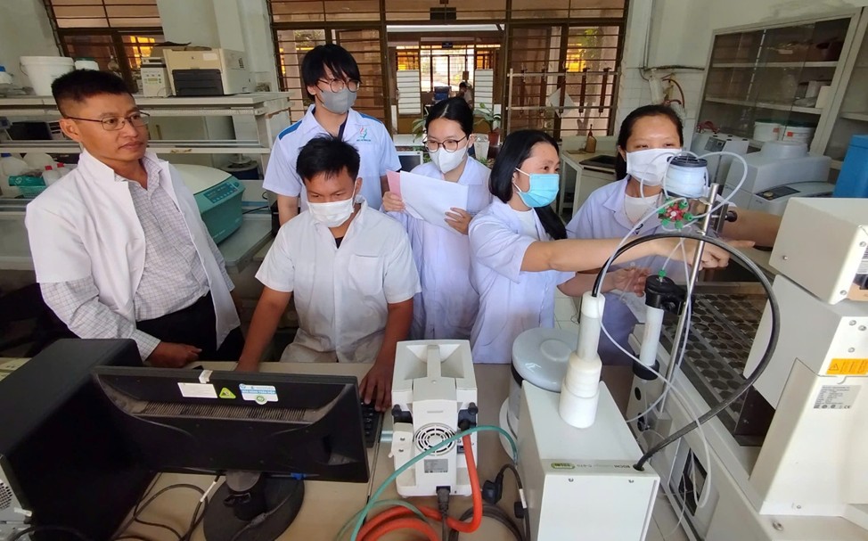 TS. Bùi Đình Thạch (ngoài cùng bên trái) trao đổi với nhóm nghiên cứu tại phòng thí nghiệm
