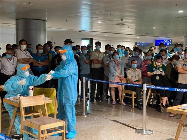 Nhân viên y tế làm thủ tục lấy mẫu xét nghiệm cho người làm việc tại sân bay Tân Sơn Nhất. (Ảnh: TTXVN phát)