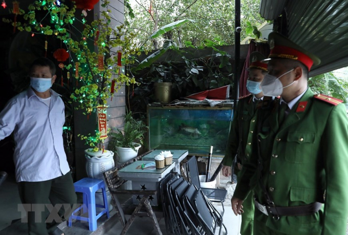 Lực lượng công an nhắc nhở người dân đóng cửa quán cà phê tại khu đô thị Văn Quán, quận Hà Đông. Ảnh: Phan Tuấn Anh/TTXVN