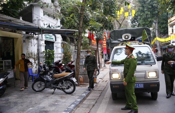 Lực lượng công an phường Hàng Mã ra quân đề nghị các hộ kinh doanh đóng cửa quán ăn đường phố, trà đá, cà phê. Ảnh: Doãn Tuấn/TTXVN