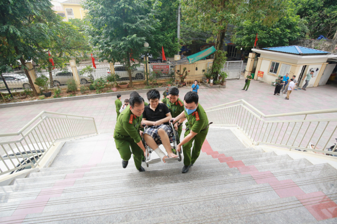 Nạn nhân bị thương được công an hỗ trợ đưa đến nhận hỗ trợ - Ảnh: UBND TP Hà Nội