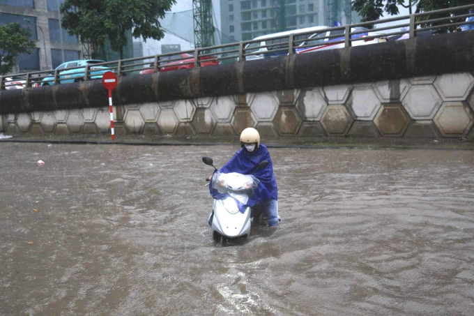 Nhiều người buộc phải dắt xe trên đường Châu Văn Liêm do nước ngập quá cao