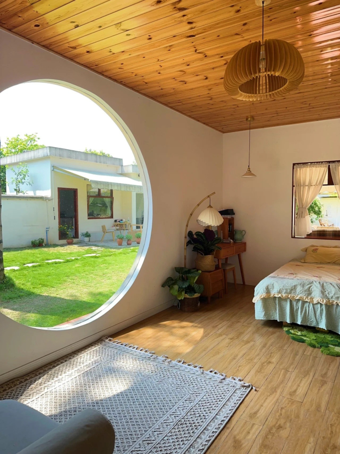 Căn nhà chính có phòng ngủ nhỏ và chiếc cửa sổ hình tròn xinh xắn.                         