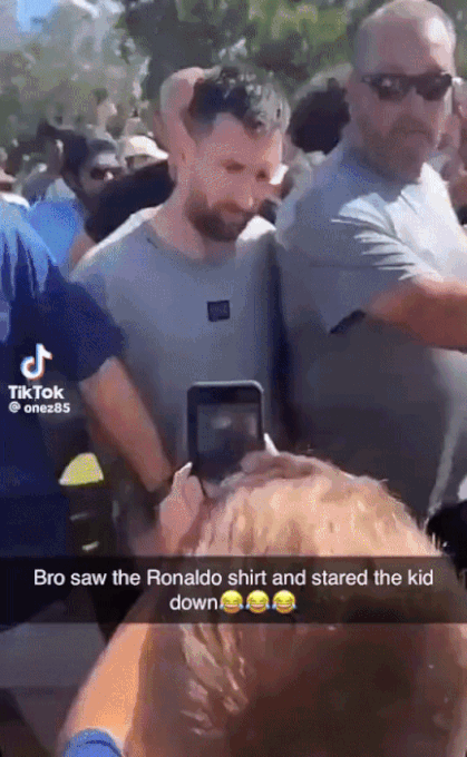 Messi dường như không vui khi bị một fan giơ áo đấu của Ronaldo ra trước mặt