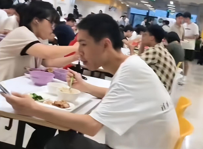 Giữa canteen đông đúc, nam sinh Thanh Hoa này vừa ăn vừa nhìn chằm chằm vào điện thoại