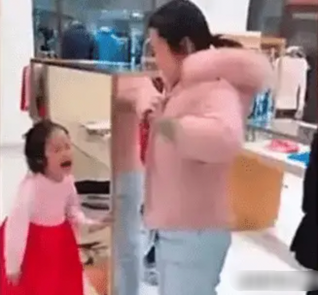 Cha mẹ dẫn theo con gái đi chơi ở trung tâm thương mại. (Ảnh cut từ clip)