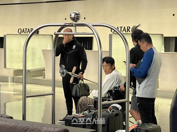 Seung-gyu ngồi xe lăn ra sân bay về nước hôm 23/1. Ảnh: Sport Gate