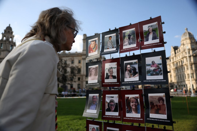 Một người phụ nữ đang nhìn vào ảnh của các nạn nhân trong bê bối truyền 