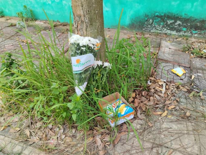 Người dân đặt hoa trắng, sữa, bim bim tại nơi phát hiện cháu bé bị bỏ quên trên xe đưa đón