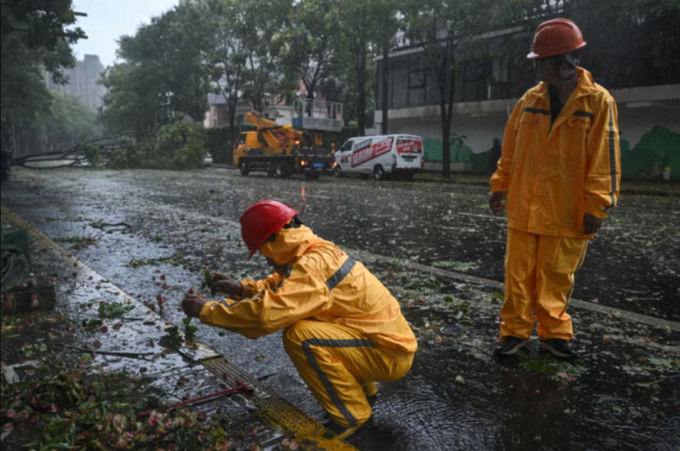 Công nhân môi trường dọn dẹp khi cơn bão đi qua (Ảnh: AFP)