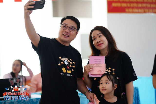 Nhiều cử tri chụp ảnh check-in bên ngoài phòng bỏ phiếu (Ảnh: Lê Trung & Di Anh)