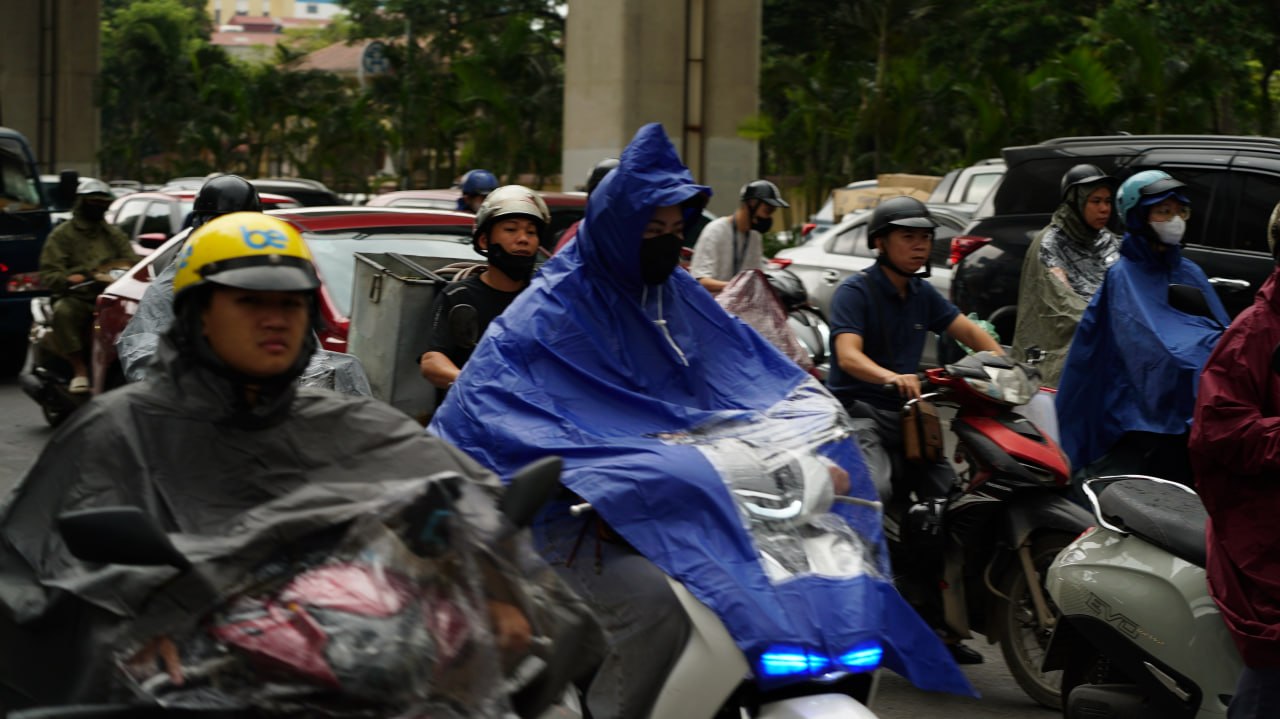 Mưa nhỏ kèm gió khiến nhiều người mặc áo mưa (Ảnh: NXH)