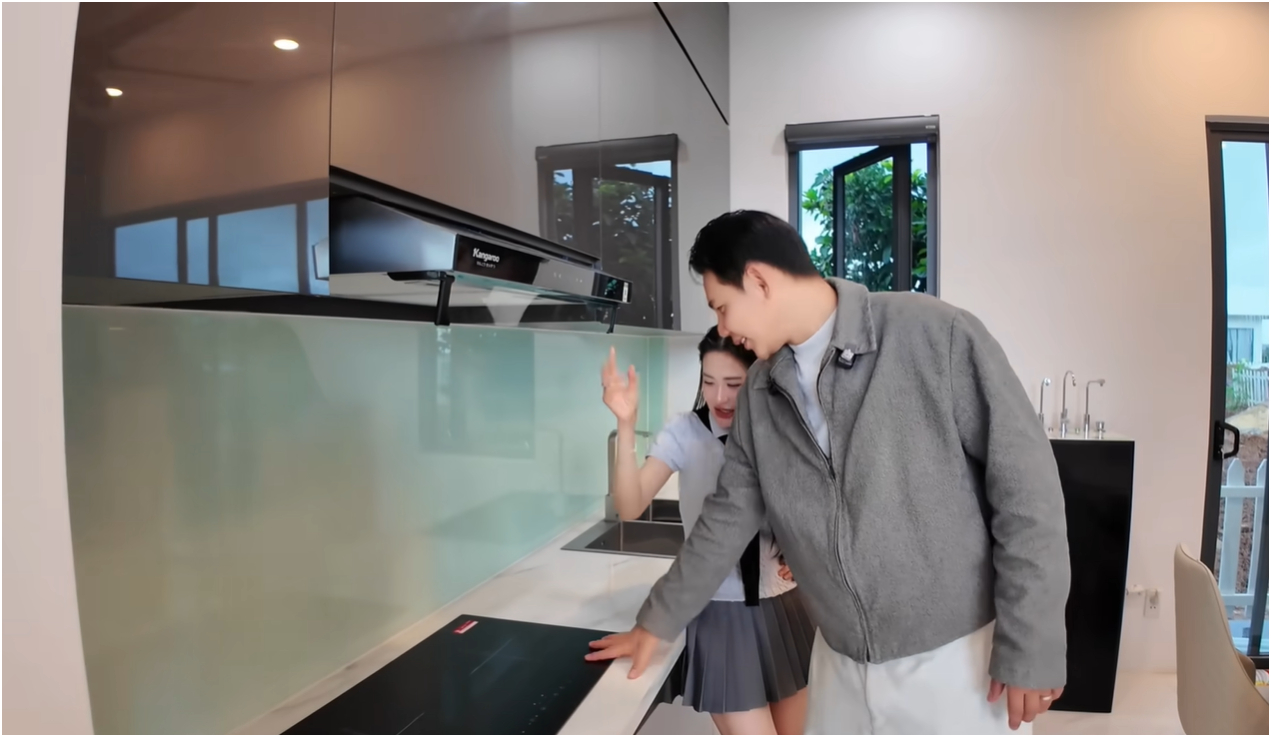 Ngay cạnh đó là khu bếp - dù cả hai từng thừa nhận “không ai biết nấu ăn” - vẫn được đầu tư đầy đủ thiết bị hiện đại. Bàn ăn được đặt liền kề, tạo thành một không gian sinh hoạt liền mạch, tiện lợi.