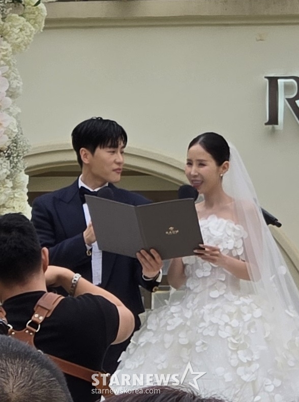Tân lang tân nương trao lời thề nguyện trước sự chứng kiến của dàn quan khách. Chú rể MoonOne đã không thể rời mắt được khỏi bà xã trong giờ phút thiêng liêng. Ảnh: Naver