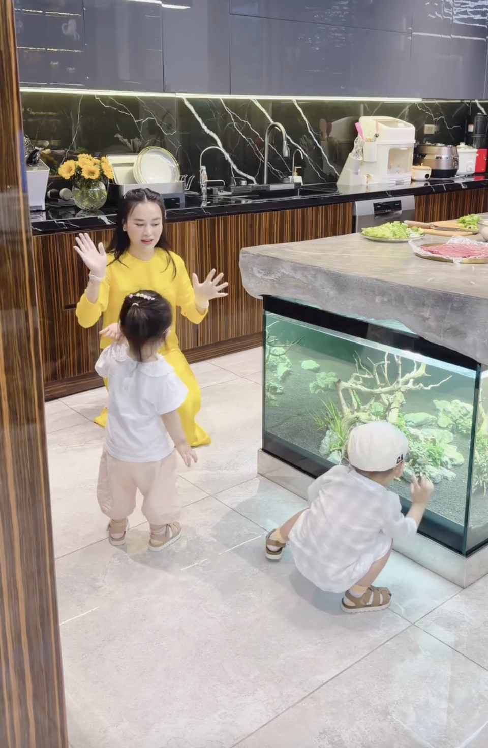 Có lúc, Phương Oanh phải vừa nấu nướng vừa chăm sóc các con 