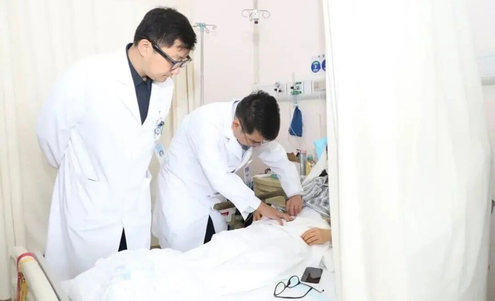 Bác sĩ Trần Khải Nghĩa đang kiểm tra nữ bệnh nhân sau phẫu thuật cắt bỏ đại trực tràng