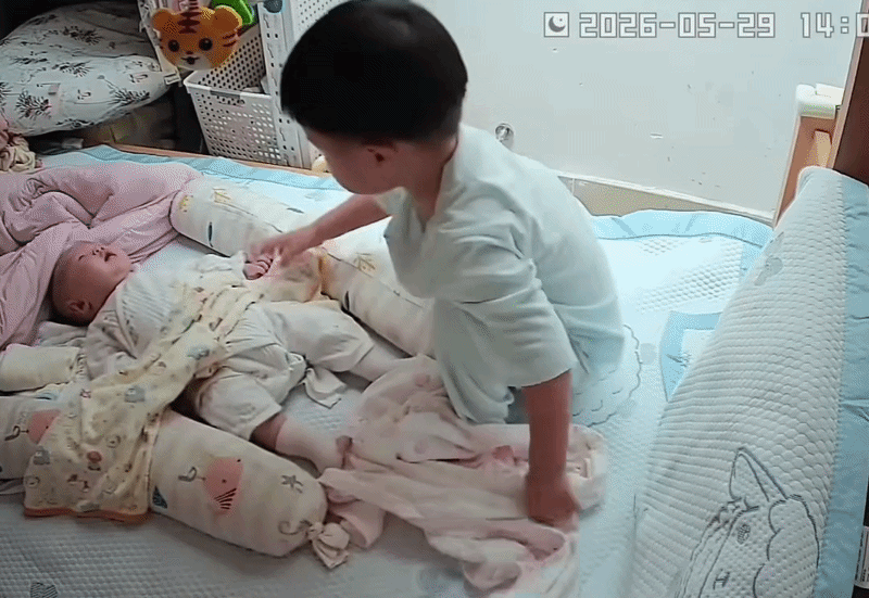 Cậu bé mới 2 tuổi nhưng đã biết chăm sóc cho em út mới sinh lúc mẹ không có ở bên