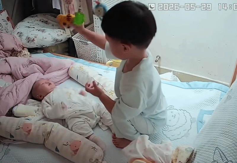 Khi thấy em khóc, cậu bé biết rung chuông treo nôi để dỗ em