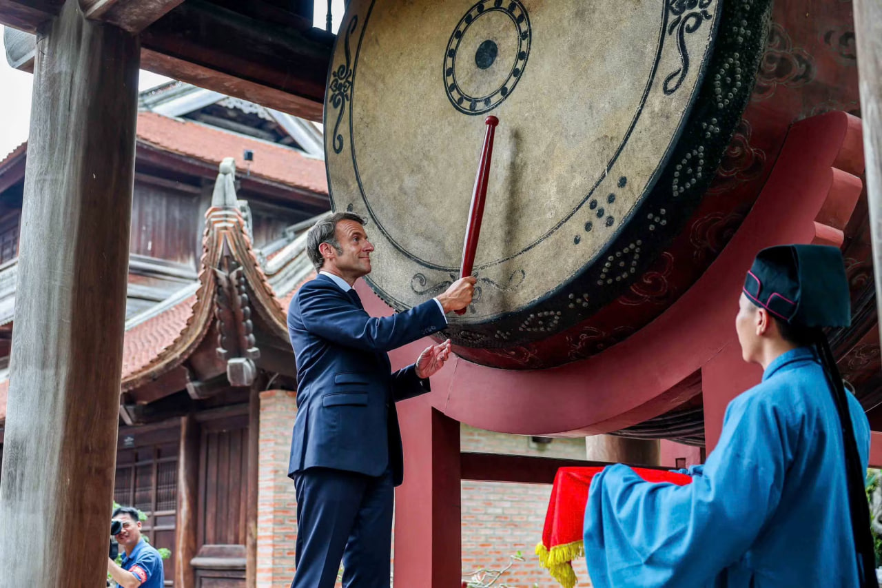 Tổng thống Pháp Macron thực hiện nghi lễ đánh trống Sấm ở Văn Miếu - Quốc Tử Giám. Ảnh: Tiền Phong