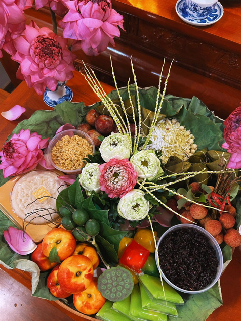 Mâm cỗ quy tụ nhiều thức quà đặc trưng của Tết Đoan Ngọ được đặt giữa không gian thờ cúng với sắc hồng của những đóa sen. (Ảnh: Mỹ Hạnh)