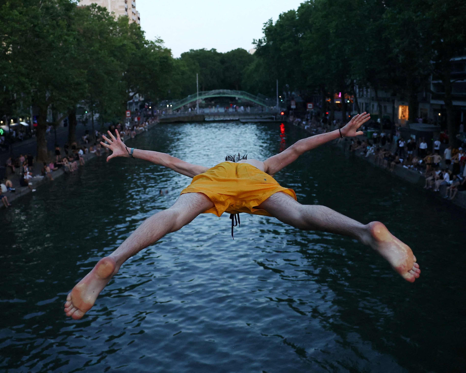 Một người đàn ông nhảy xuống nước ở kênh đào Saint-Martin khi nhiệt độ ở Paris tăng cao. Ảnh: Abdul Saboor/Reuters