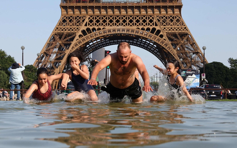 Người dân giải nhiệt tại Đài phun nước Trocadero cạnh Tháp Eiffel ở Paris. Ảnh: Abdul Saboor/Reuters