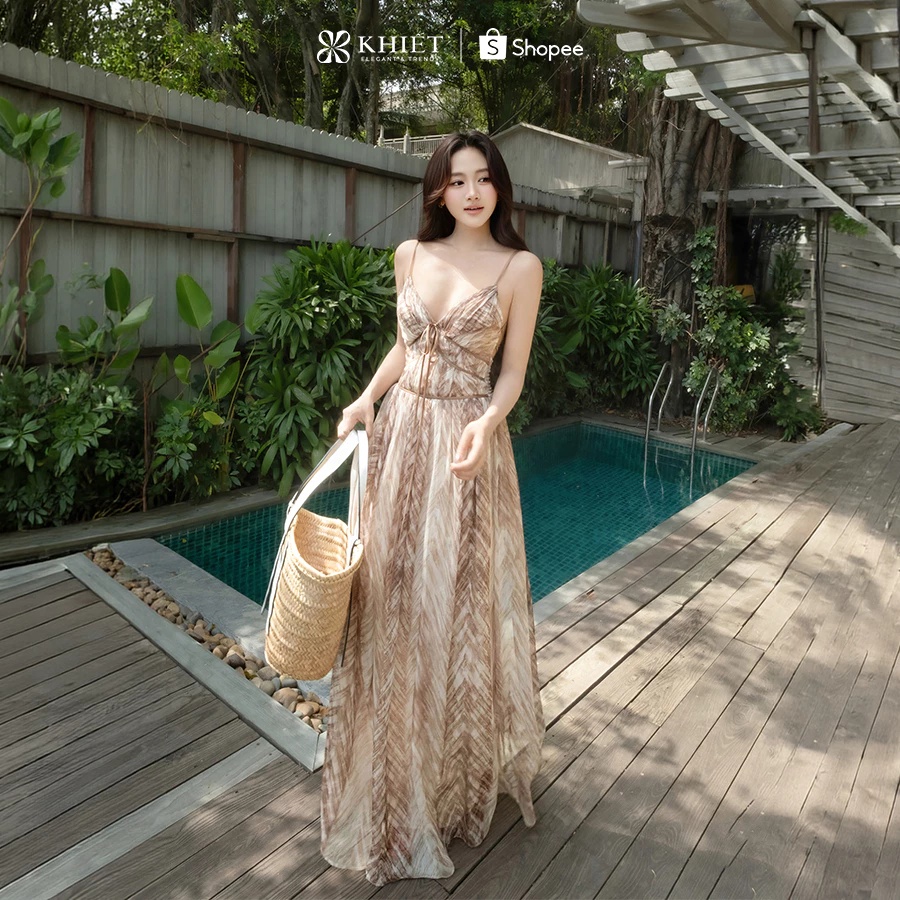 Những cô nàng yêu thích phong cách điệu đà, quyến rũ sẽ khó lòng cưỡng lại sức hút của mẫu váy maxi này. Váy có thiết kế cổ chữ V ôm nhẹ vòng eo, kết hợp phần lưng đan dây tinh xảo giúp khoe khéo tấm lưng trần và tạo hiệu ứng vóc dáng cân đối hơn. Khi chuyển động, tà váy mềm mại tung bay theo từng bước chân, mang đến vẻ đẹp vừa phóng khoáng, vừa sang trọng, rất hợp cho những buổi dạo biển hay tiệc hoàng hôn.