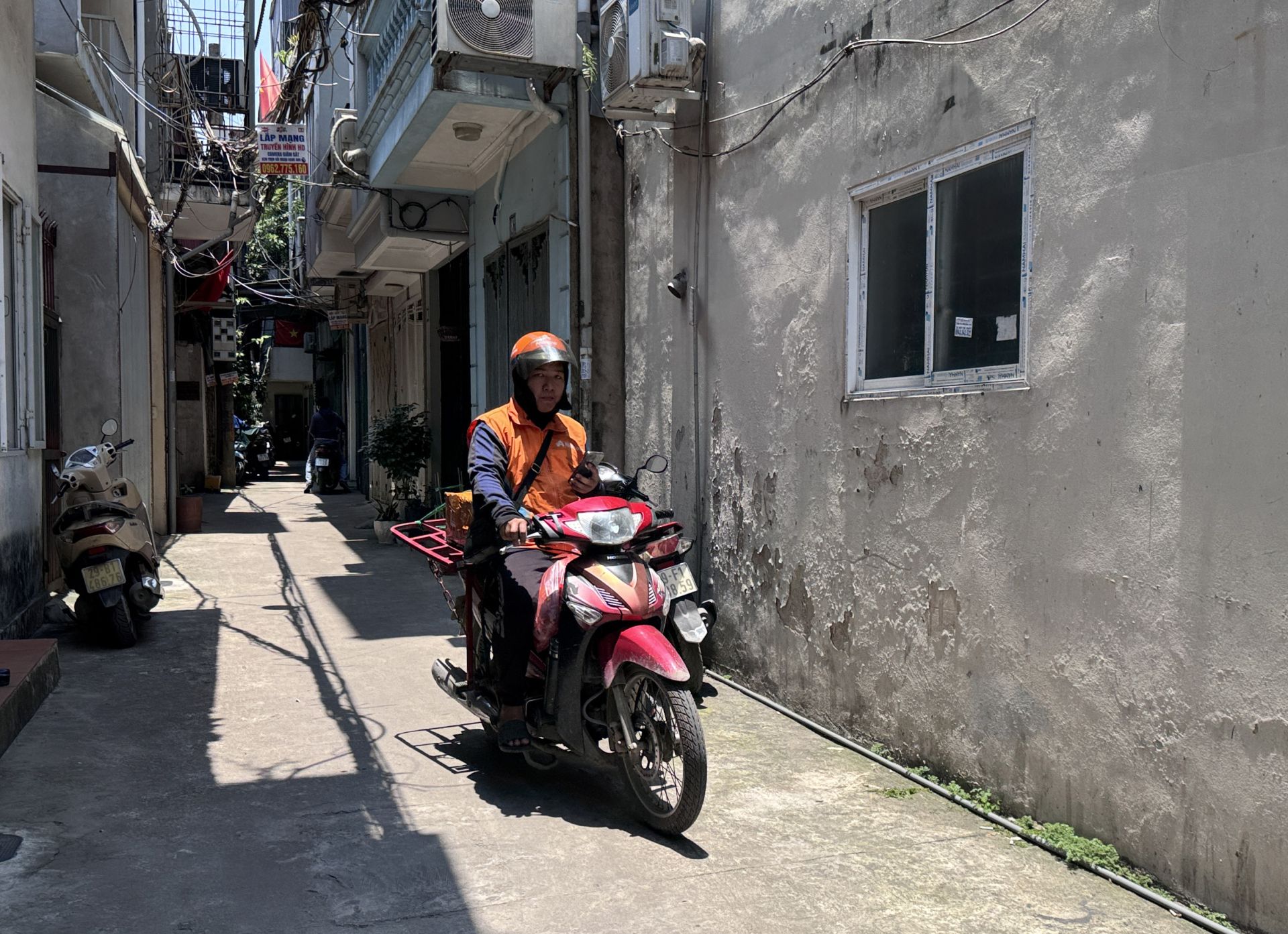 Một shipper phải chờ hơn 10 phút để lấy bánh giao cho đại lý. Ảnh: Hoàn Như