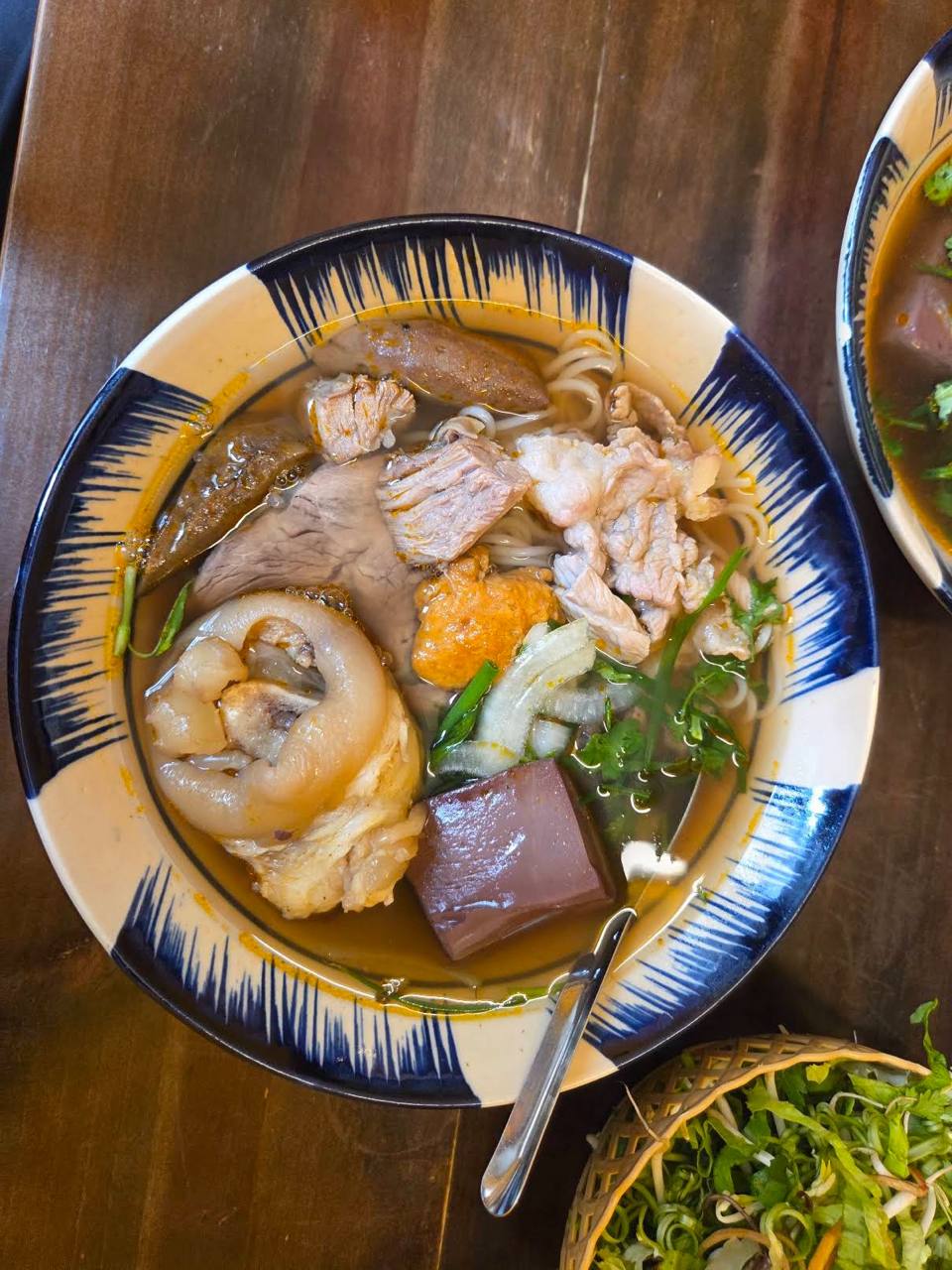 Một bán bùn bò Huế có các topping như giò heo, tiết, chả cua, thịt bò,...