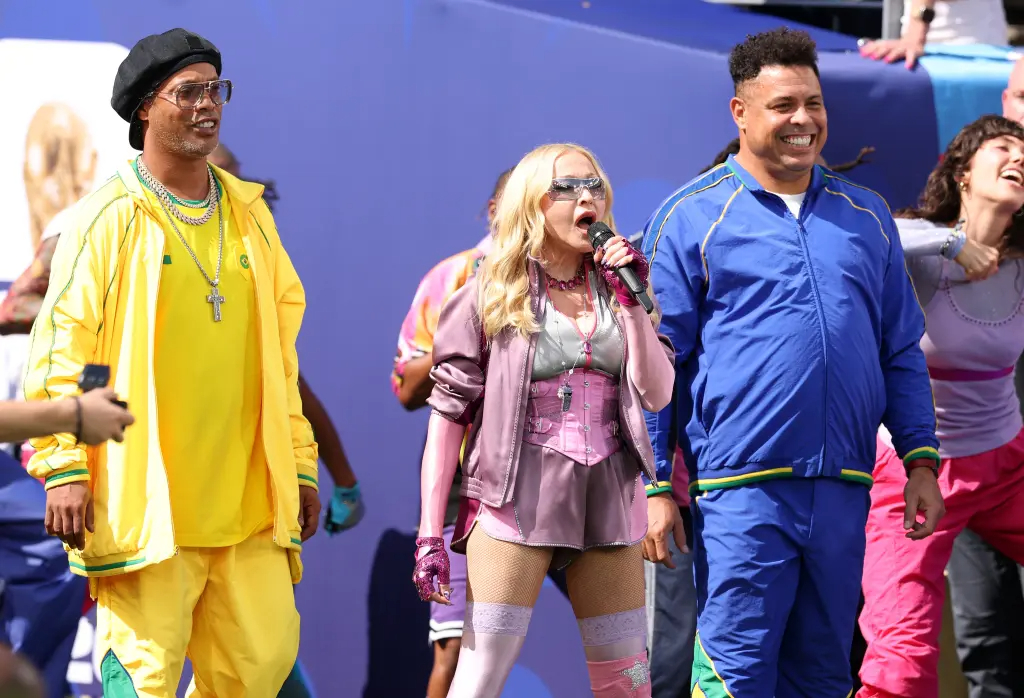 Madonna là người trình diễn đầu tiên trong halftime show trong trận chung kết. Nữ ca sĩ được 2 huyền thoại bóng đá Ronaldo và Ronaldinho tháp tùng. Ở ngưỡng U70, Madonna vẫn duy trì được sự trẻ trung đáng ngưỡng mộ. Ảnh: Getty Images.