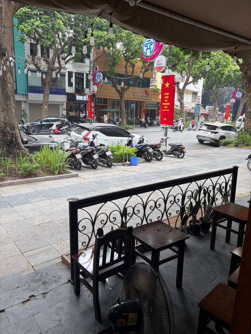 Ngoài hiên, nhiều người chọn những bộ bàn ghế gỗ để vừa uống cà phê vừa ngắm dòng xe qua lại trên phố Trần Hưng Đạo