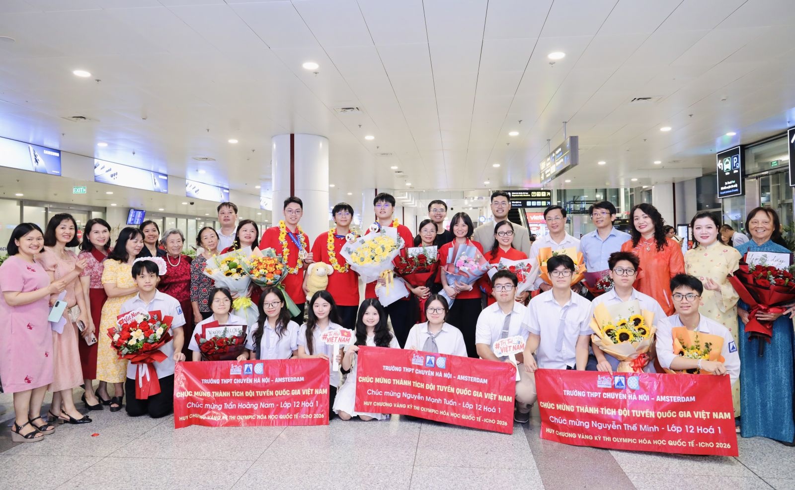 3 học sinh đoạt Huy chương Vàng Trường THPT chuyên Hà Nội - Amsterdam chụp ảnh cùng các thầy cô giáo và người thân (Ảnh: MOET)