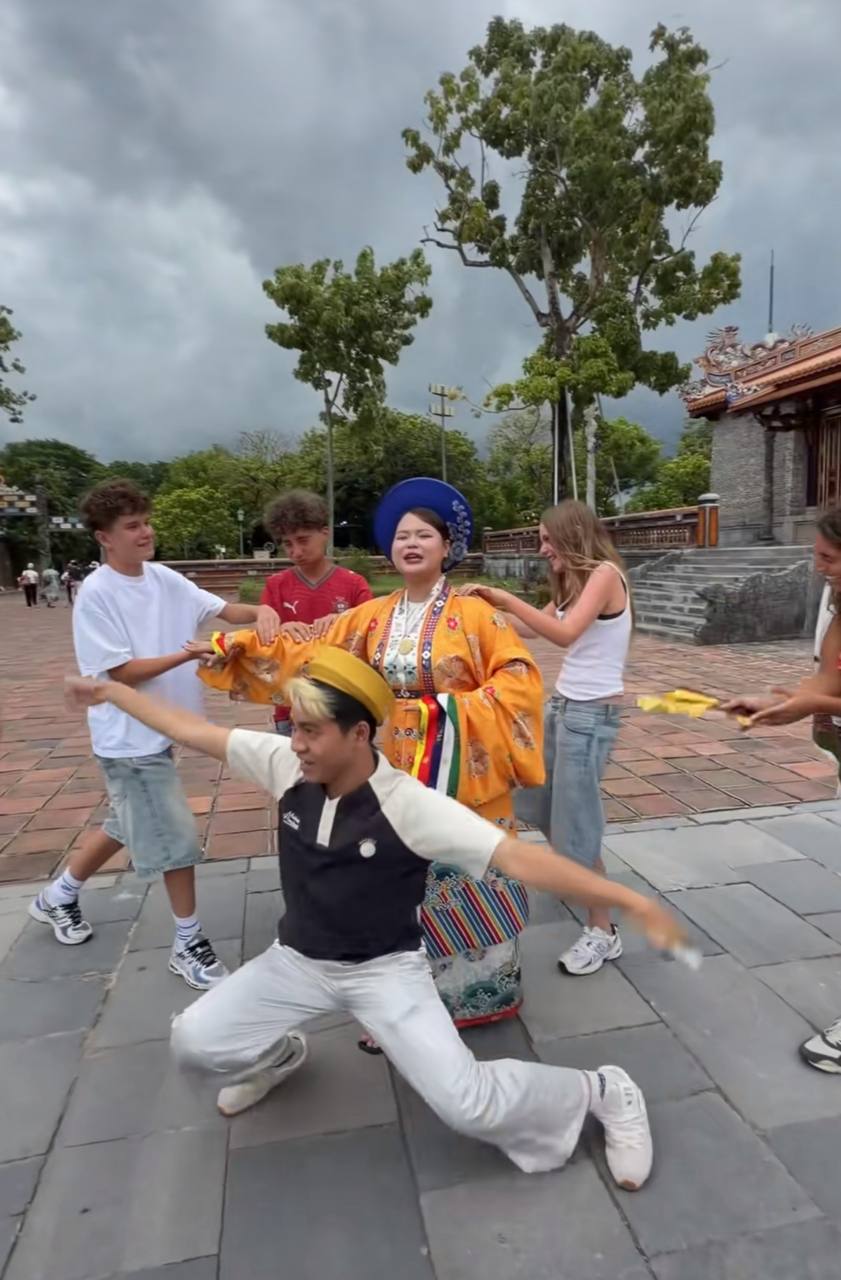 Nấm Hương hóa thân thành một vị hoàng hậu quyền uy, ung dung đứng giữa sân và nhờ bốn vị khách du lịch nước ngoài đứng xung quanh bóp tay, bóp vai, phe phẩy quạt