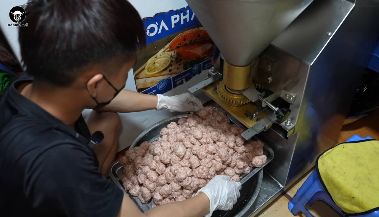 Nhân viên đổ thịt vào phễu, bấm nút, máy sẽ tự động đùn thịt qua khuôn tròn rồi ngắt