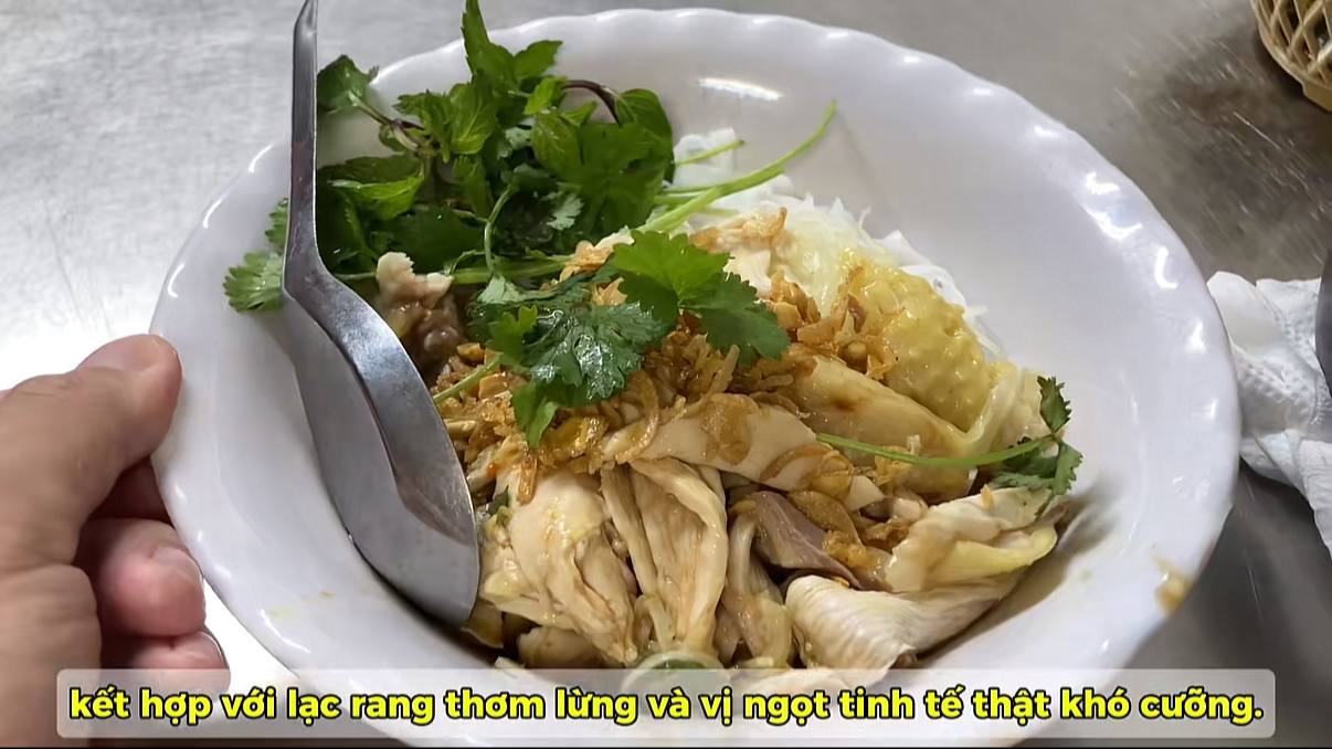 Bát phở gà trộn của Hitoshi có phần bánh phở mềm, thịt gà xé phủ bên trên, xen giữa là rau thơm, hành khô và lạc rang. Khi trộn lên, phần nước xốt chua ngọt bám đều vào từng sợi phở. Nguồn: Hitoshi Mission