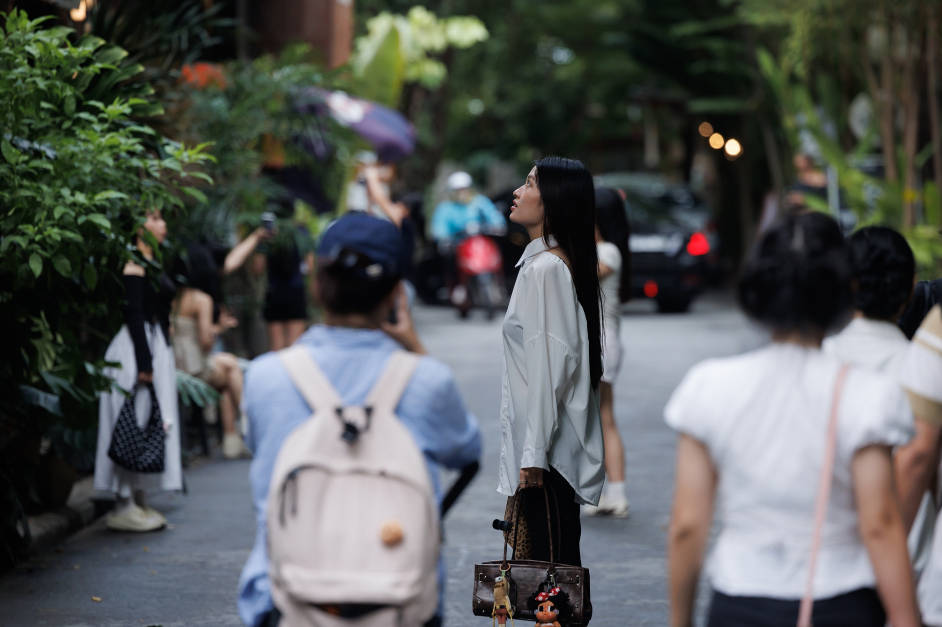 Không chỉ ngồi cà phê, nhiều bạn trẻ còn tranh thủ chụp ảnh tại những góc mặt tiền, con hẻm và khoảng không gian xanh đặc trưng của Số 28 Thảo Điền. Lượng khách không quá đông nhưng phân bổ đều dọc tuyến hẻm.