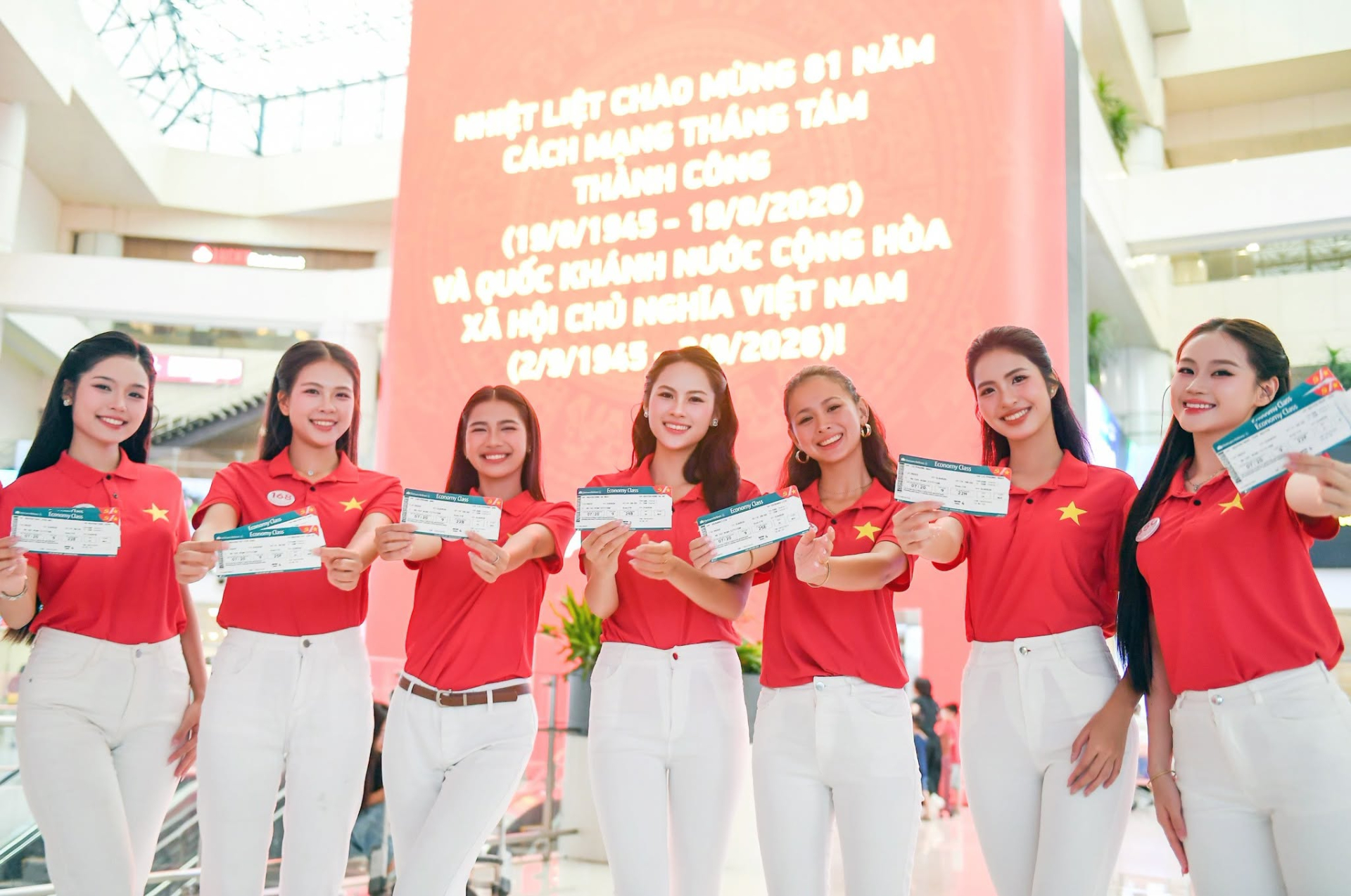 Các thí sinh Hoa hậu Việt Nam 2026 nhận thẻ lên tàu được thiết kế riêng với hình ảnh cờ Tổ quốc.