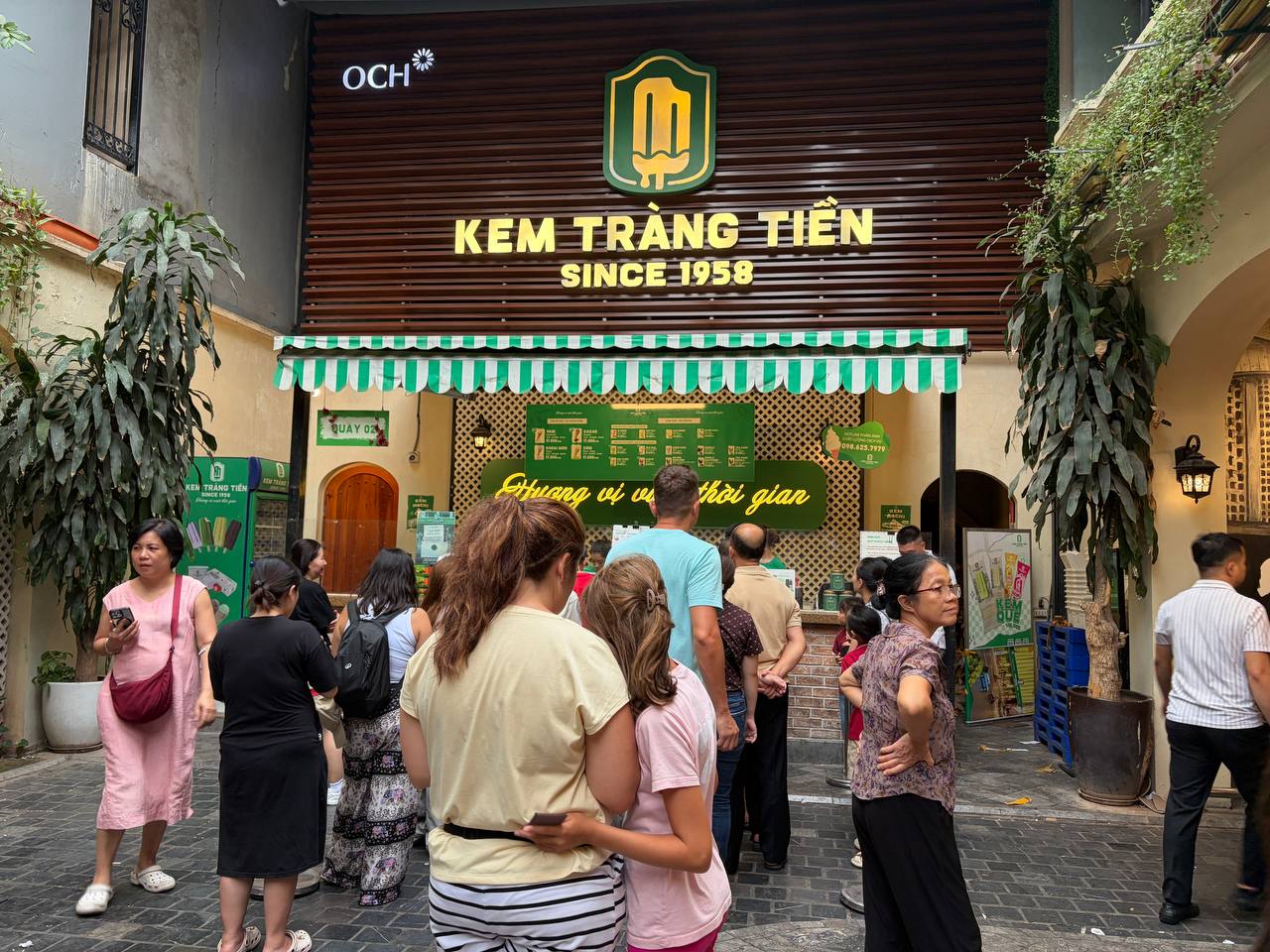  Mọi người kiên nhẫn đứng thành hàng, lần lượt chọn vị kem rồi tìm chỗ ngồi hoặc mang ra ngoài thưởng thức.