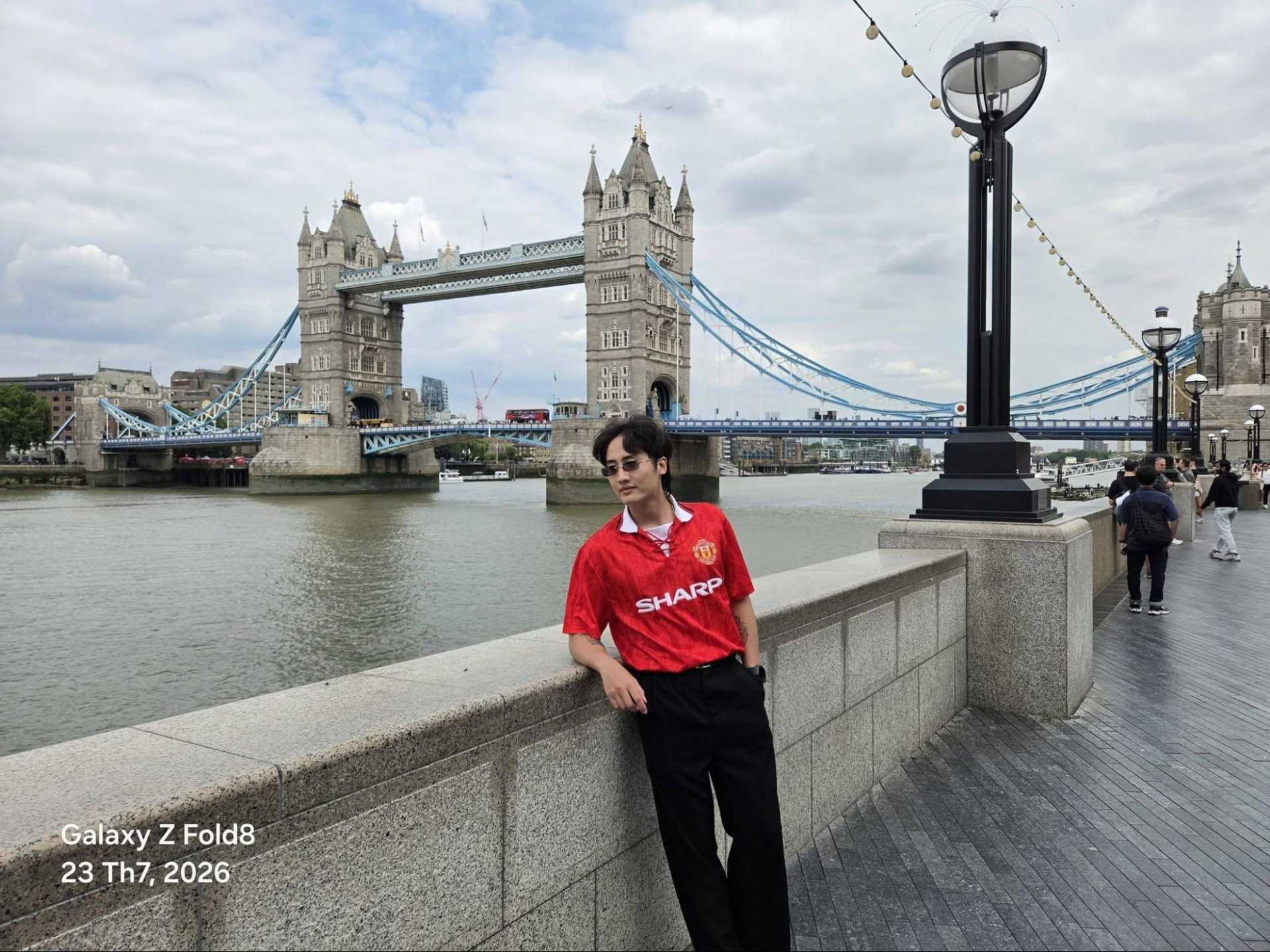 Bờ nam sông Thames là chỗ chật, phía sau lưng người chụp chỉ vài mét là lối đi bộ đông người. Ở khoảng cách đó, khung ảnh vẫn ôm được cả hai tháp của Tower Bridge, dải cầu treo bên trái và cột đèn cao bên phải, tức là không phải hy sinh chi tiết nào để đổi lấy chi tiết khác.